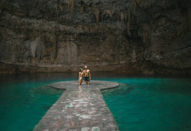 Couple standing  in Cenote in Yucatan, Mexico Young Caucasian heterosexual couple  standing in the centre of Cenote in Yucatan, Mexico valladolid mexico photos stock pictures, royalty-free photos & images