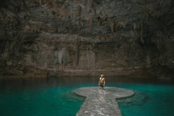 istock Man standing  in Cenote in Yucatan, Mexico 1395795542