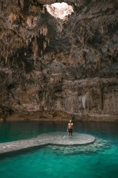 istock Man standing  in Cenote in Yucatan, Mexico 1395795777