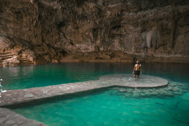 istock Man standing  in Cenote in Yucatan, Mexico 1395796358