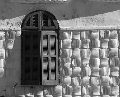 Antique old arch window with wooden window shutters,in black and white.