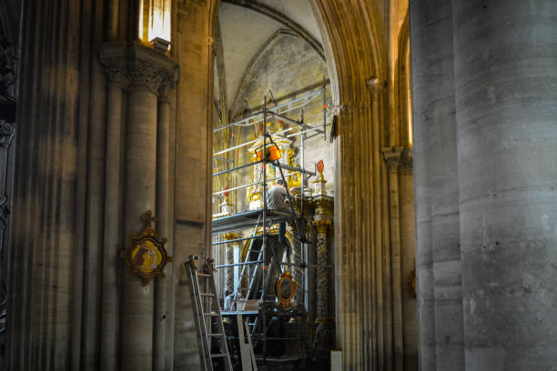 un restaurador de arte masculino se sienta en un andamio mientras trabaja en una pared en la catedral de nuestra señora de bayeux en el departamento de calvados en bayeux, normandía, francia. - restoring art painting artist fotografías e imágenes de stock