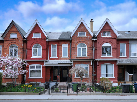 Urban residential street with row of attached old houses with gables