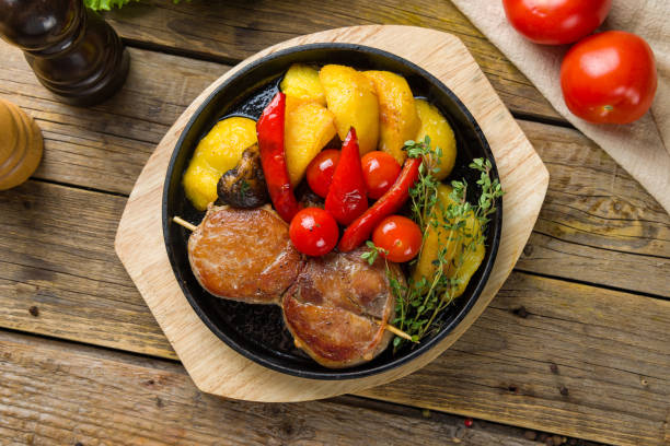Pork medallions with fried potatoes and vegetables top view