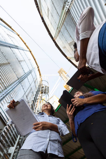 istock Women of various ethnicities engineers working in a grain silo 1395808317