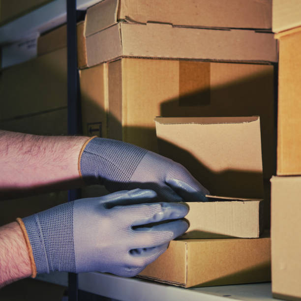 istock A man in gloves steals goods from a box in a warehouse. Problems with theft and security in the office 1395810279