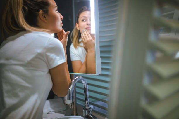 istock A young woman applies face cream. 1395810321