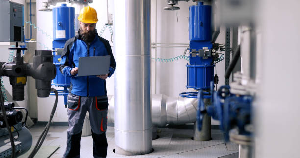 istock A focused heating plant worker uses a laptop. 1395810336