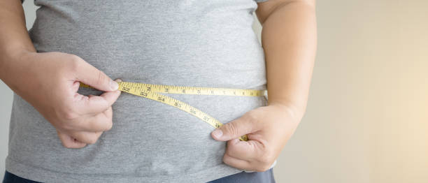istock An obesity using measuring tape to show the real size. 1395814848