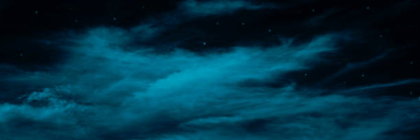 istock Night sky. Clouds illuminated by moonlight. Beautiful dark sky background with space for design. 1395823160