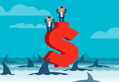 Economic crisis and business risk, two desperate businessmen standing on dollar sign surrounded by sharks.