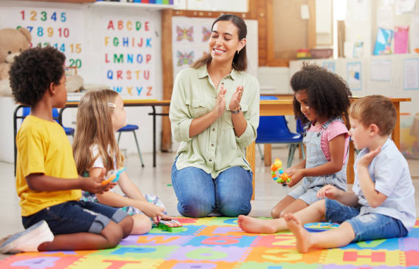 foto de una maestra cantando con sus hijos en edad preescolar - child looking blank offspring fotografías e imágenes de stock