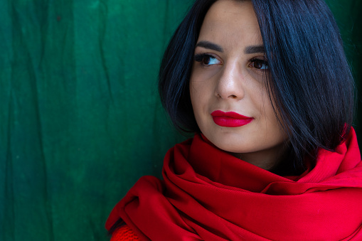 Portrait of eastern brunette girl with red scarf looking aside