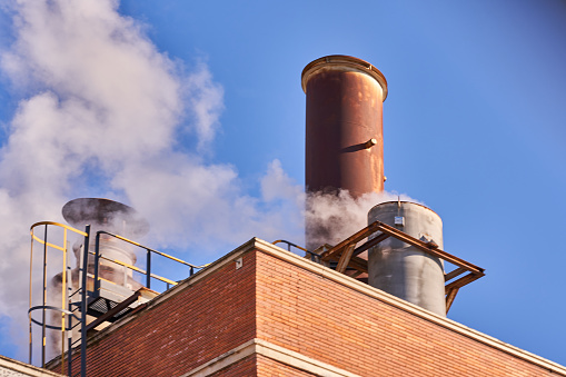 Industrial chimney releasing fumes, steam and polluting gases. High quality photo