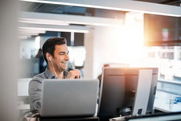 Photo of Caucasian businessman talking customer service on phone in office