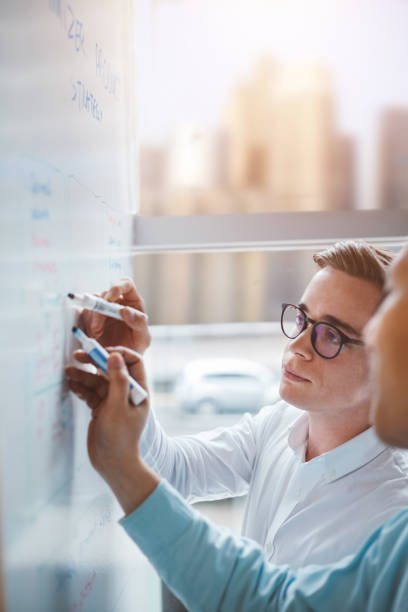 istock Pair of colleagues working together brainstorming in modern office 1395838020
