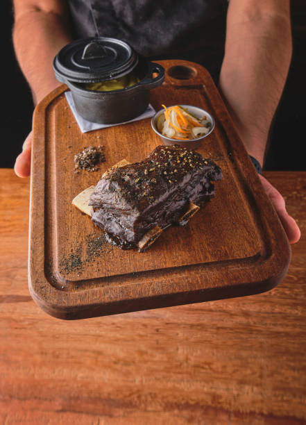 chef présentant de la viande rôtie en bande avec du poivre, accompagnée de purée de pommes de terre et de légumes cuits à la vapeur. focus sélectif, viande gourmande - steak meat strip steak restaurant photos et images de collection