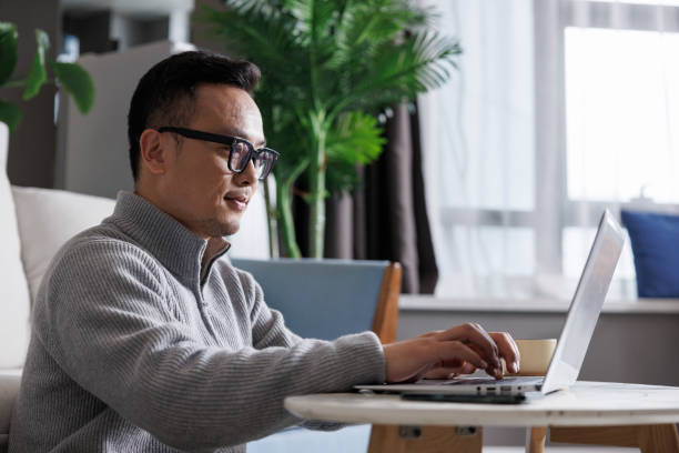 istock middle-aged man working on laptop at home 1395840067