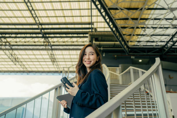 istock Young businesswoman using the phone while walking 1395840870