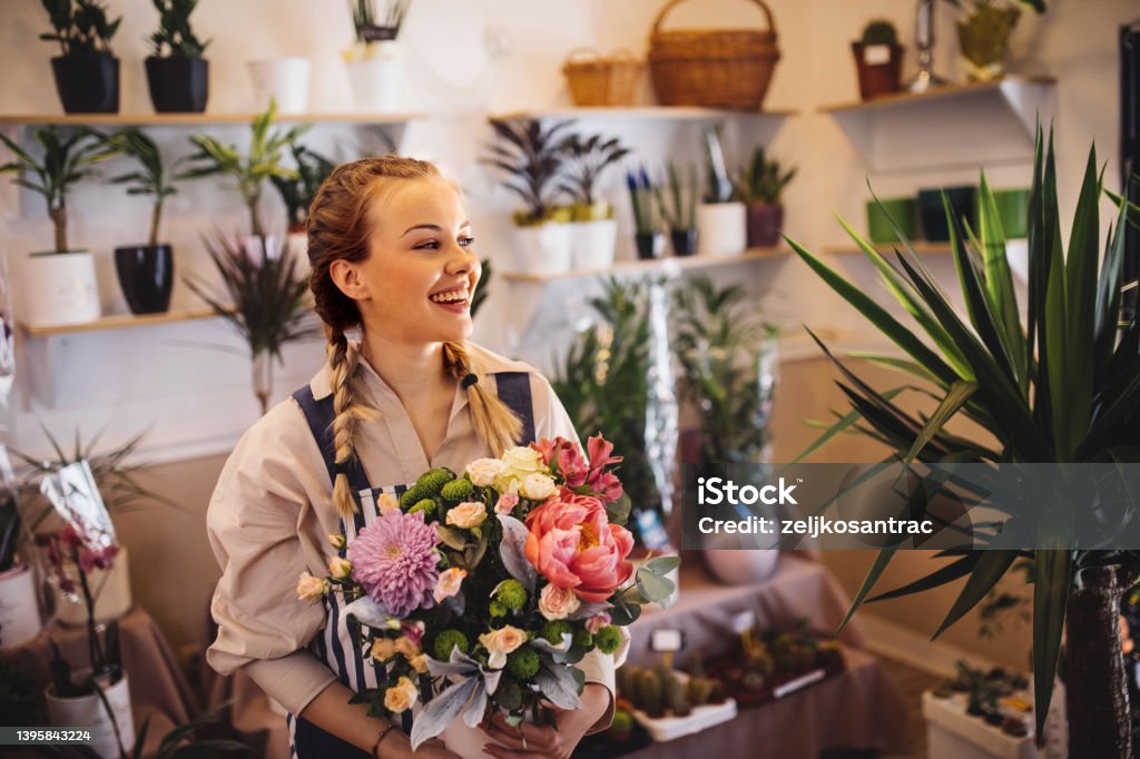 Mother and daughter taking care of the plants in their floral shop Mother and daughter taking care of the plants in their floral shop -new business Flower Arrangement Stock Photo