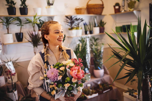 Mother and daughter taking care of the plants in their floral shop stock photo