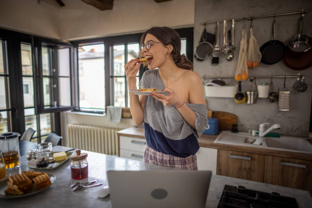istock Woman enjoys breakfast in her kitchen 1395843261