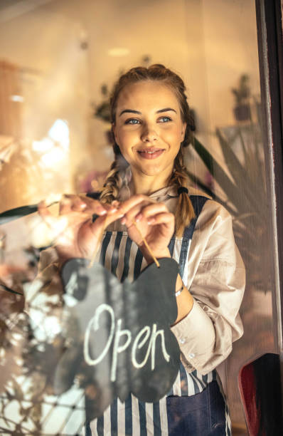 istock Young florist holding sign open and smiling 1395844075