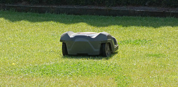 A robotic lawnmower does its job on the lawn. The grass is kept pretty short