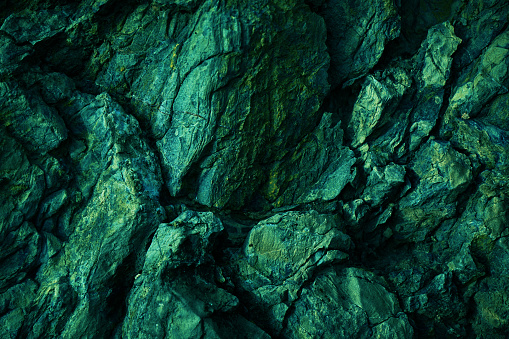 Green yellow rock texture. Toned rough mountain surface texture. Crumbled. Close-up. Rocky background with space for design.