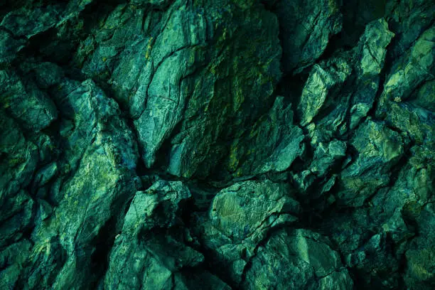 Photo of Green yellow rock texture. Toned rough mountain surface texture. Crumbled. Close-up.