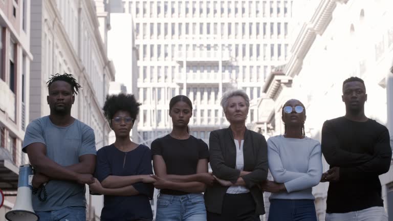 Diverse group of people standing together in the street during a protest. Crowd of people standing together in solidarity as they march together at a rally