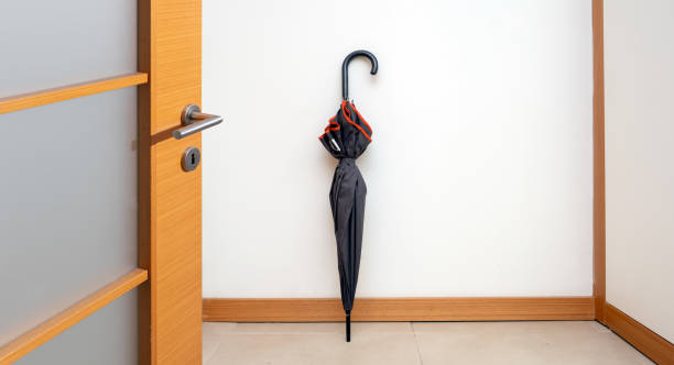 istock umbrella standing in front of white wall 1395850050