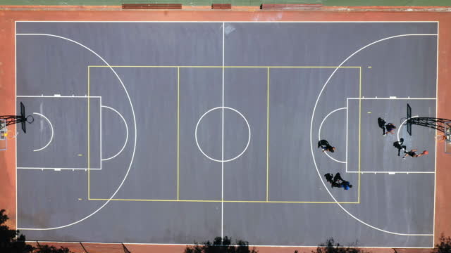 Overhead of a group of unrecognizable men playing a game of basketball. Young men playing sport from above