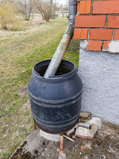 istock A black barrel for sewage is attached to the house by the gutter. 1395854471