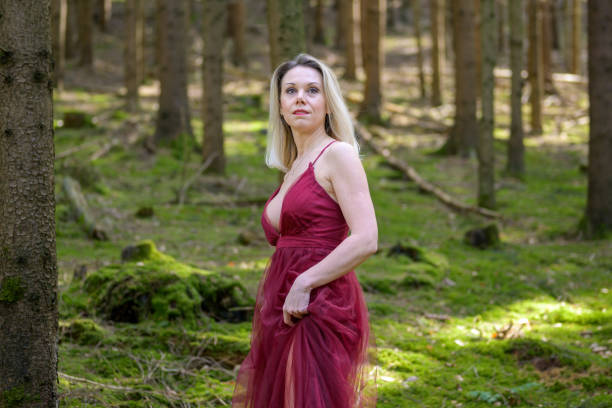 istock Beautiful woman looking away standing at forest 1395854501
