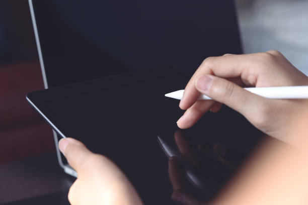 istock Business woman hand holding and using digital tablet and working on laptop computer, close up. 1395859456