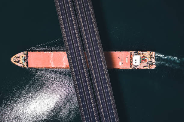 istock Aerial view of a cargo ship passing under bridge. 1395860525