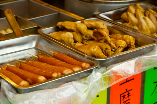 This is a food stall in China, selling sausages, chicken wings, and some hot foods.
