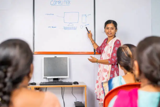 Photo of Group of Indian women listening computer class from professional teacher - concept of learning technology, empowerment and equality