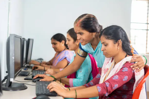 Photo of Teacher helping or teaching students during computer class training - concept of learning, personal support and technology.