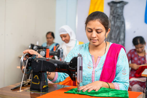 dipendenti dell'abbigliamento impegnati a lavorare con la cucitura di stoffa in fabbrica - concetto di duro lavoro, lavoratore autonomo e piccola impresa - sewing textile garment industry foto e immagini stock