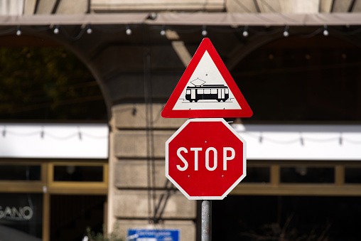 Traffic signs warning from passing trams and stop sign at the old town of Basel on a sunny spring day.