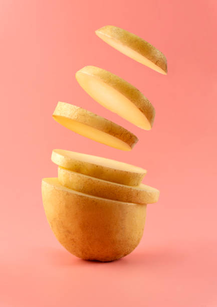 kartoffeln und in scheiben geschnittene kartoffelchips. - kartoffel grundnahrungsmittel stock-fotos und bilder