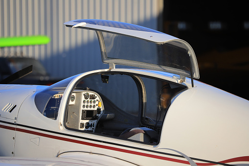 A pilot navigates a small aircraft, focusing on an array of flight instruments and digital navigation systems.