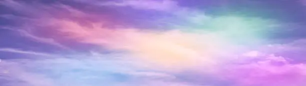 Photo of Rainbow sky with fluffy clouds. Abstract purple green yellow background with space for design. Multicolored toned sky.