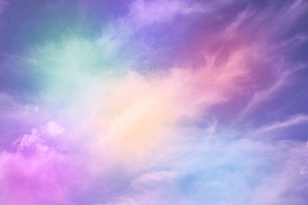 istock Rainbow sky with fluffy clouds. Abstract purple green yellow background with space for design. Multicolored toned sky. 1395872125