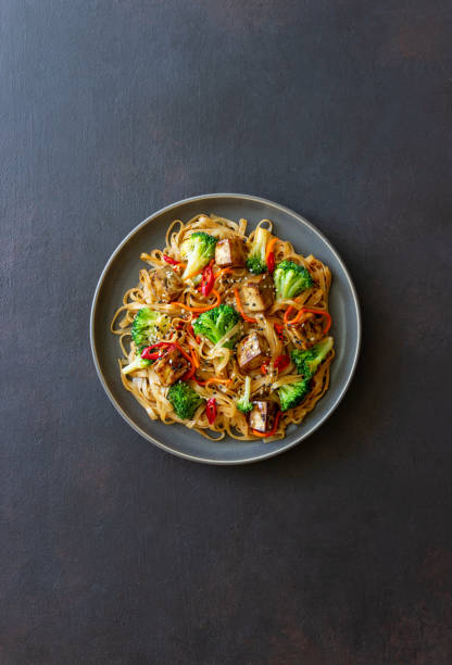 두부, 브로콜리, 당근, 후추 및 참깨를 곁들인 우동 국수. 건강한 식습관. 채식 음식. 아시아 음식. - tofu chinese cuisine vegetarian food broccoli 뉴스 사진 이미지