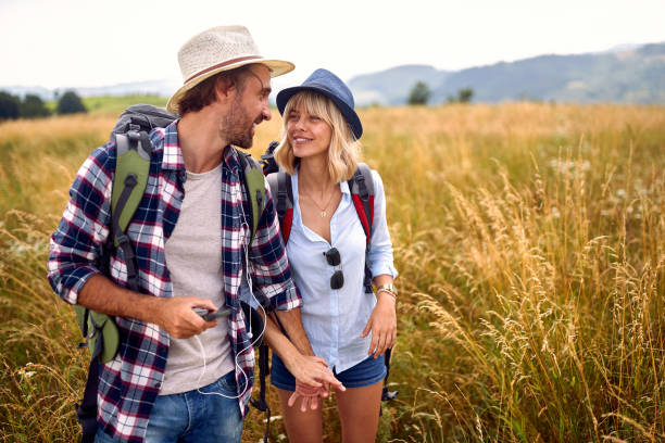 istock A young couple is chatting while walking a meadow. Hiking, nature, relationship, together 1395874240