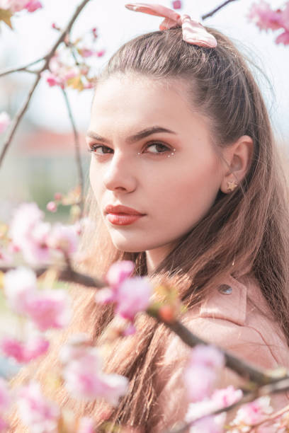 istock Beautiful woman portrait in sakura blossom background 1395883708