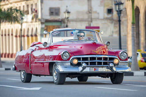 Taxi driver driving in convertible vintage car in old Havana Cuba